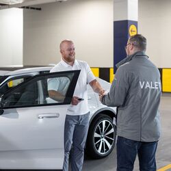 Imaginea prezintă predarea vehiculului într-un sistem automatizat de parcare, în cadrul căreia cheia vehiculului este înmânată utilizatorului după recuperarea vehiculului din sistemul de parcare.
