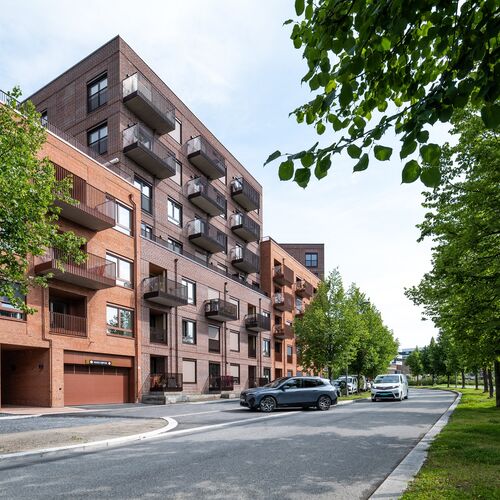 Complex rezidențial modern, în care un vehicul intră într-un garaj dotat cu un sistem de parcare integrat.