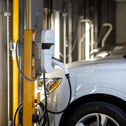 Un vehicul este parcat pe platforma unui sistem de parcare și este încărcat prin intermediul facilității integrate de încărcare pentru vehicule electrice.