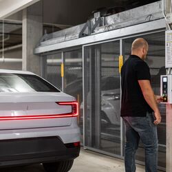 A man uses a chip to request a parking space at the parking system’s control panel