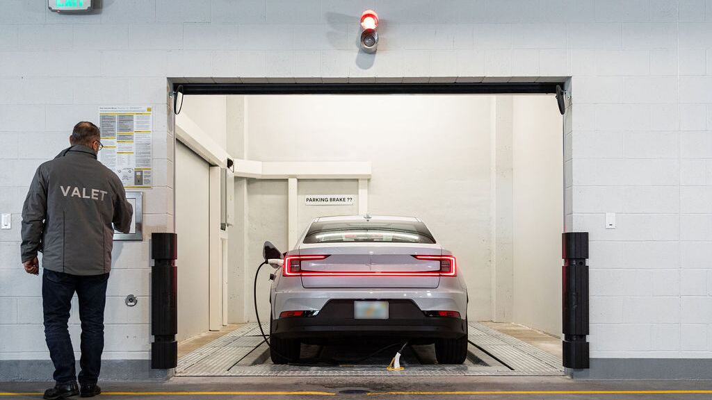 The image shows the transfer area of an automated parking system, where the driver initiates the parking process so that the vehicle is automatically transported and parked within the parking system.