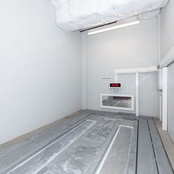 Imaginea prezintă zona de predare goală a unui sistem automatizat de parcare, unde vehiculele sunt poziționate înainte de a fi parcate automat.