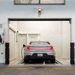 The image shows the transfer area of an automated parking system, where the driver initiates the parking process so that the vehicle is automatically transported and parked within the parking system.