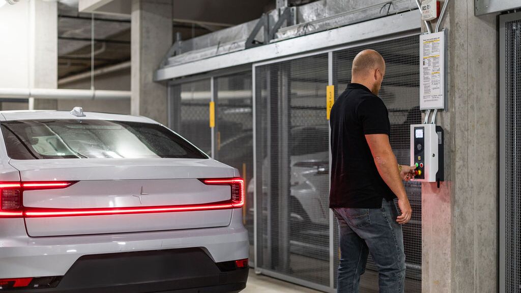A man uses a chip to request a parking space at the parking system’s control panel