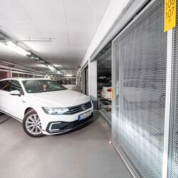 O persoană intră cu mașina într-un sistem de parcare
